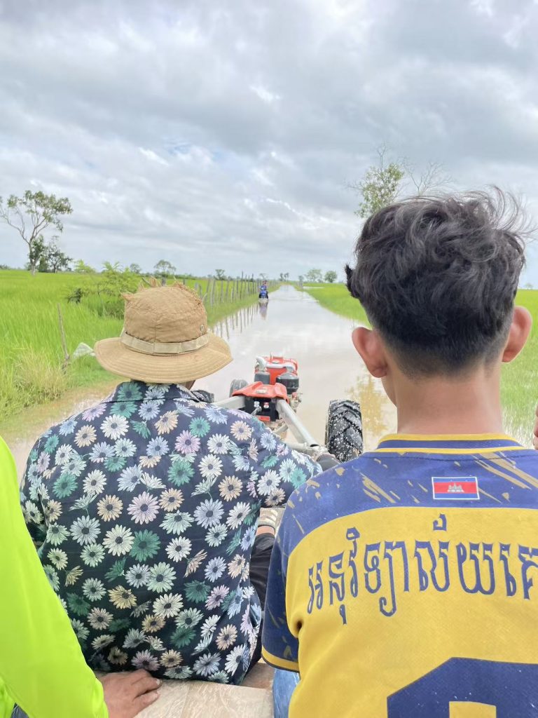 Two Cambodian villagers ride a small tractor through flooded rice fields near Tonle Sap Lake during the rainy season.