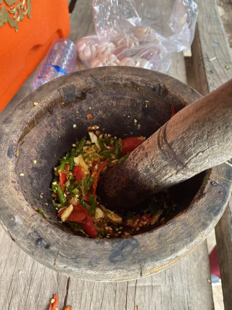 Cambodian dipping sauce made in a traditional wooden mortar with chili, garlic, and lime.