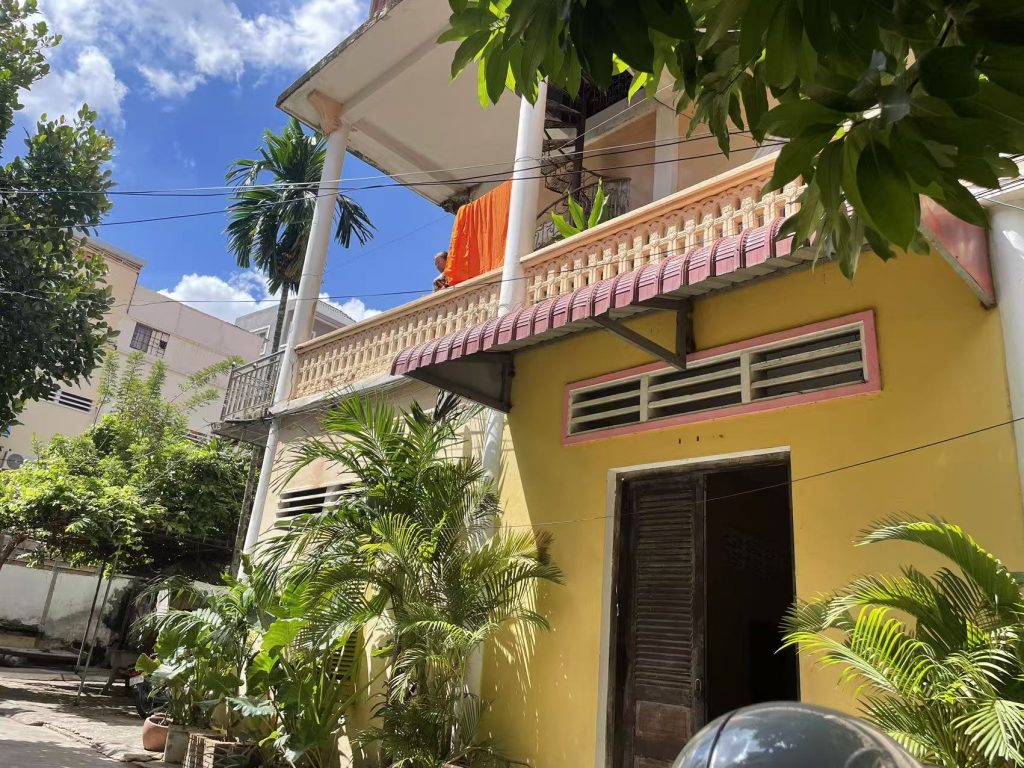 Monk residence at Wat Ounalom Monastery with orange robes hanging on the balcony.