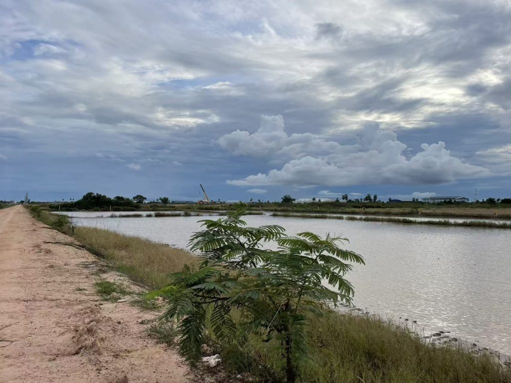 Wide view of Phnom Penh water canal and cloudy sky, symbolizing urban and natural balance in Cambodia
